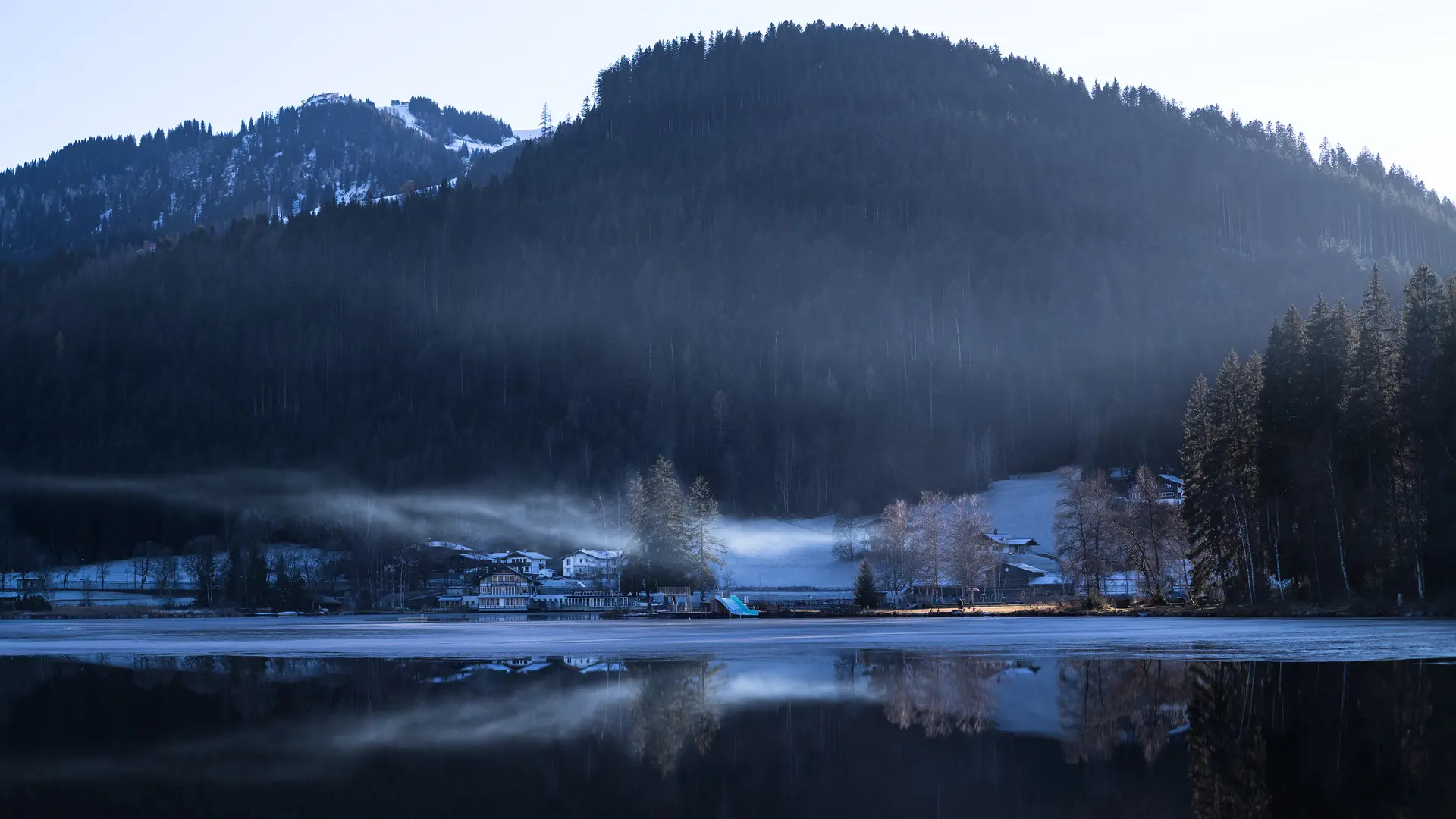 Houses by the lake surrounded by fog and snow and ice