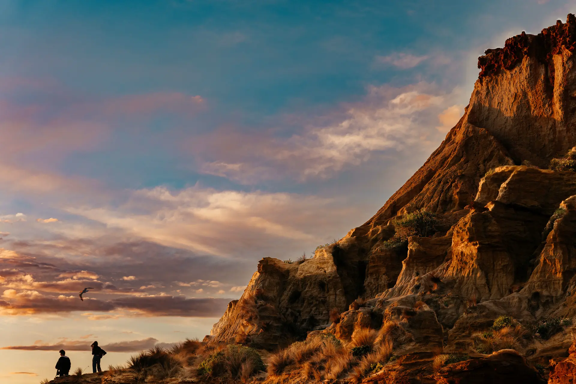 Two anglers at a rock in the sunset