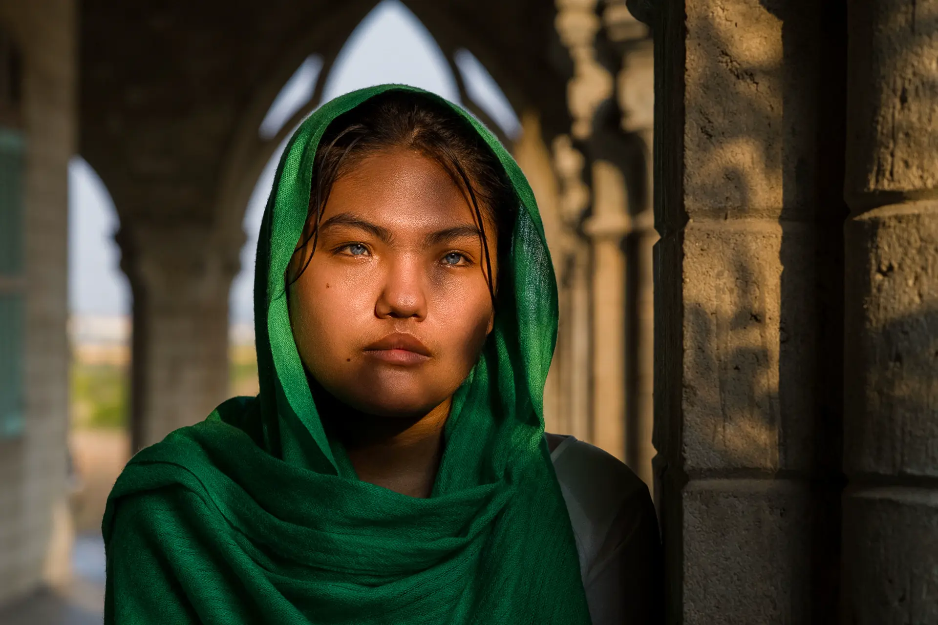 Woman with a green scarf wrapped around her neck and head