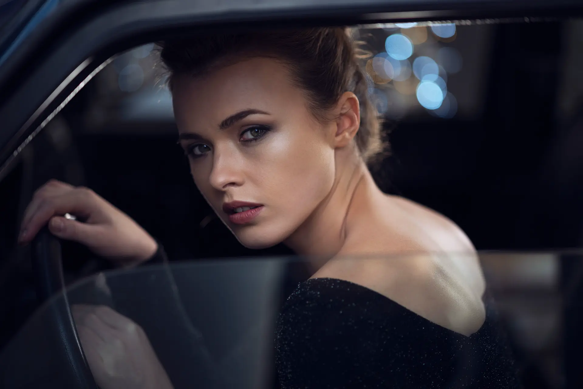 Elegant woman looks out of the car through a lowered window