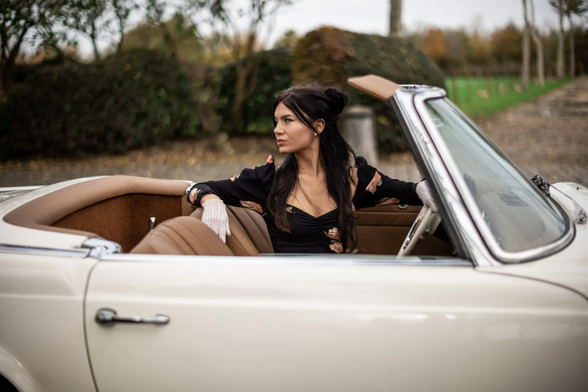 woman with brown long hairs in a oldtimer cabrio