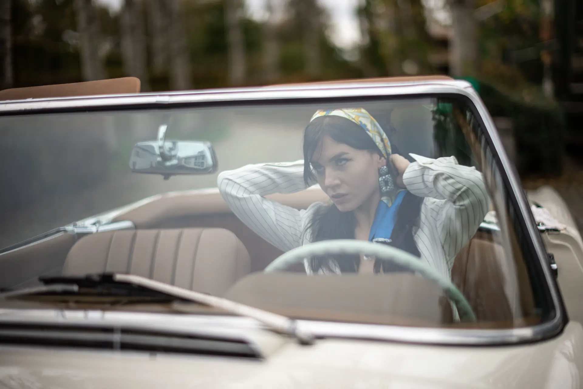 woman with brown long hairs in a oldtimer cabrio