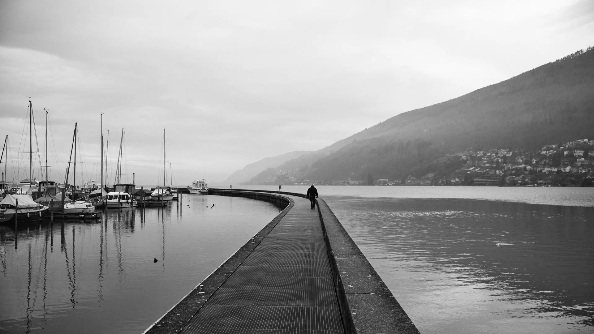 A person walking on the peer at Lake Biel