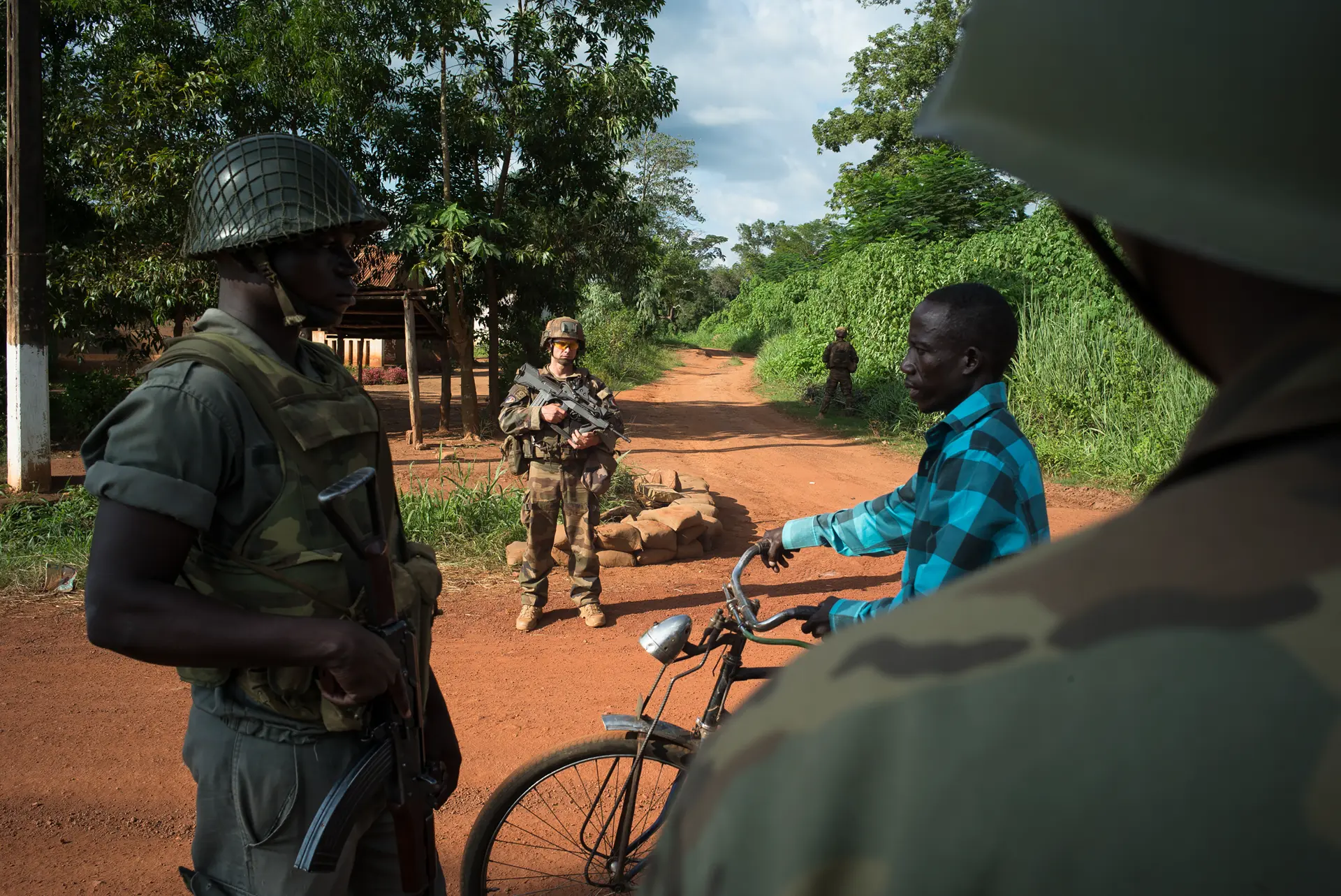 Man with bicycle surrounded by soldiers, taken in 2014 in the Central African Republic