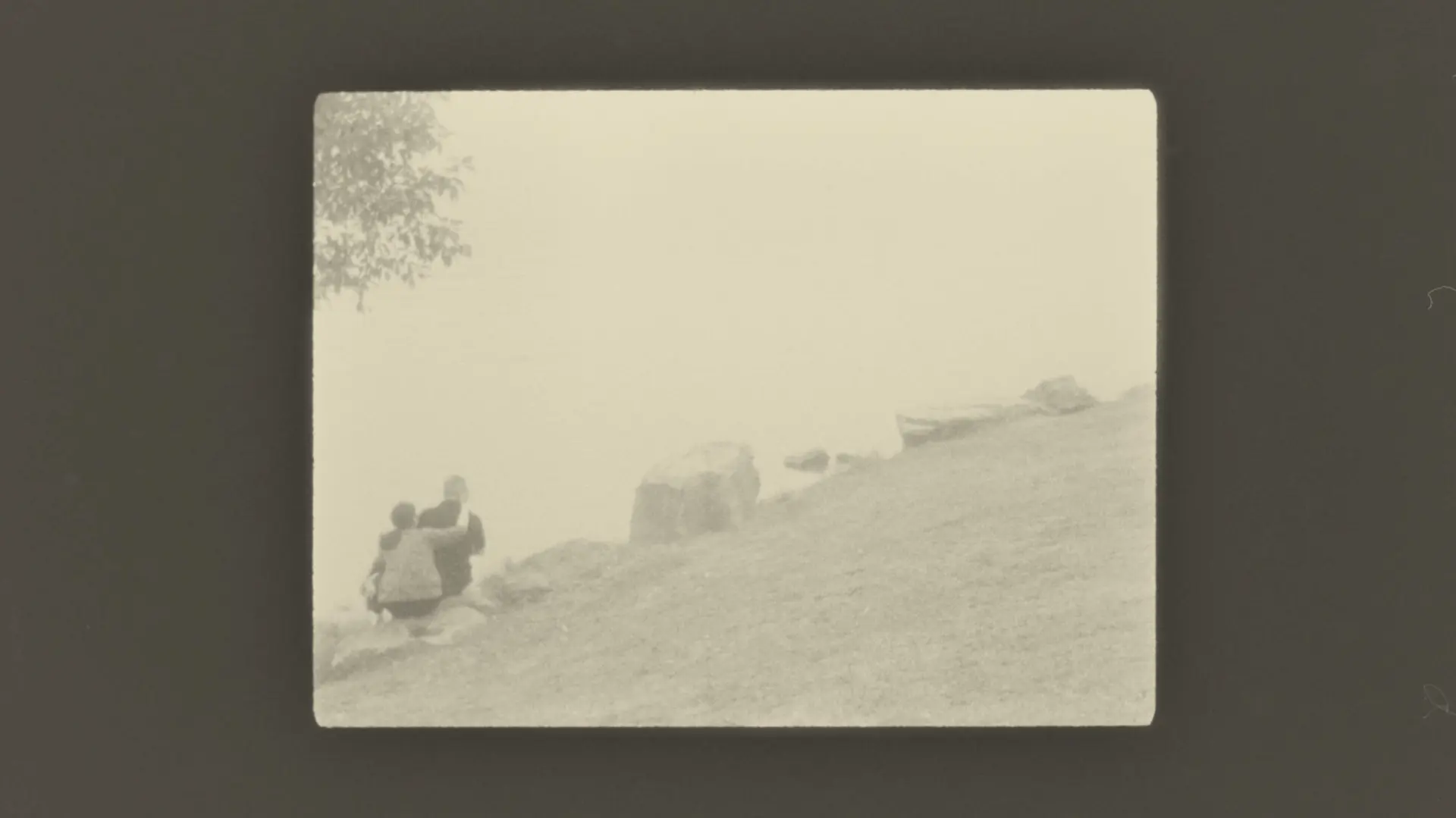 couple sitting hugging on large stones
