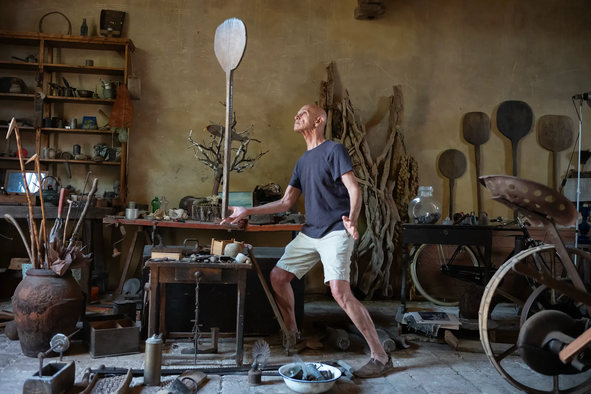 Man juggling a stick in his workshop