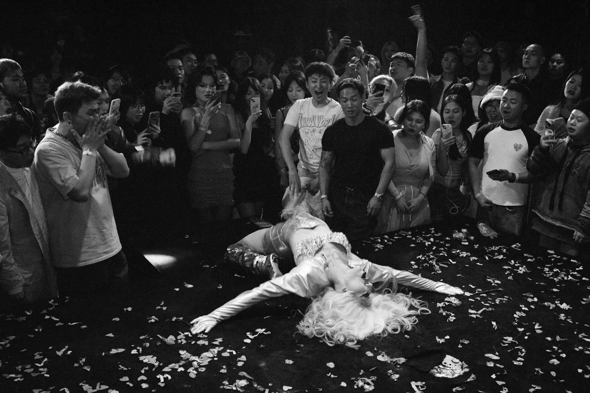 A woman on the table watched by many people.