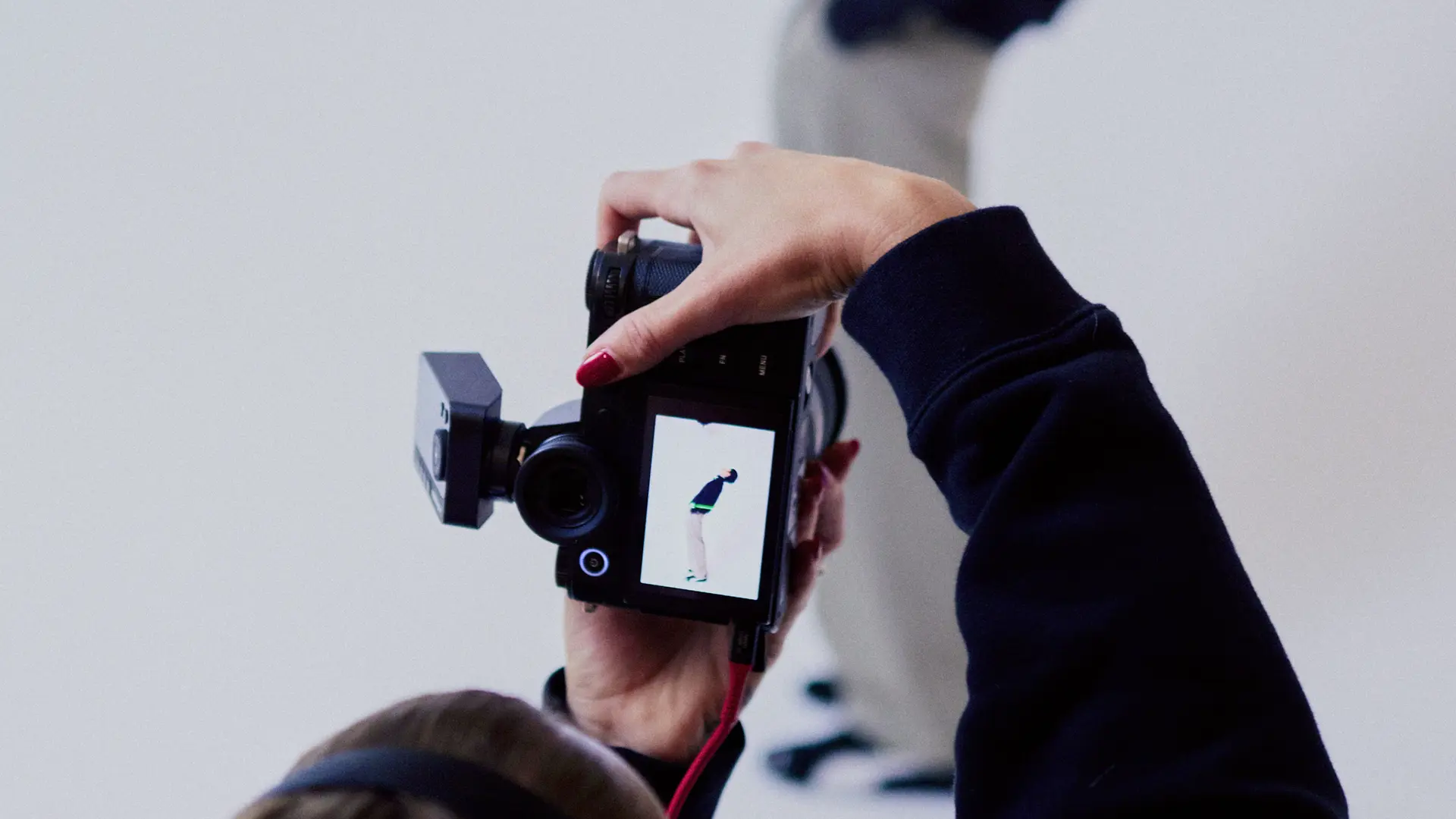 Photographer from behind in a photo studio photographing a man