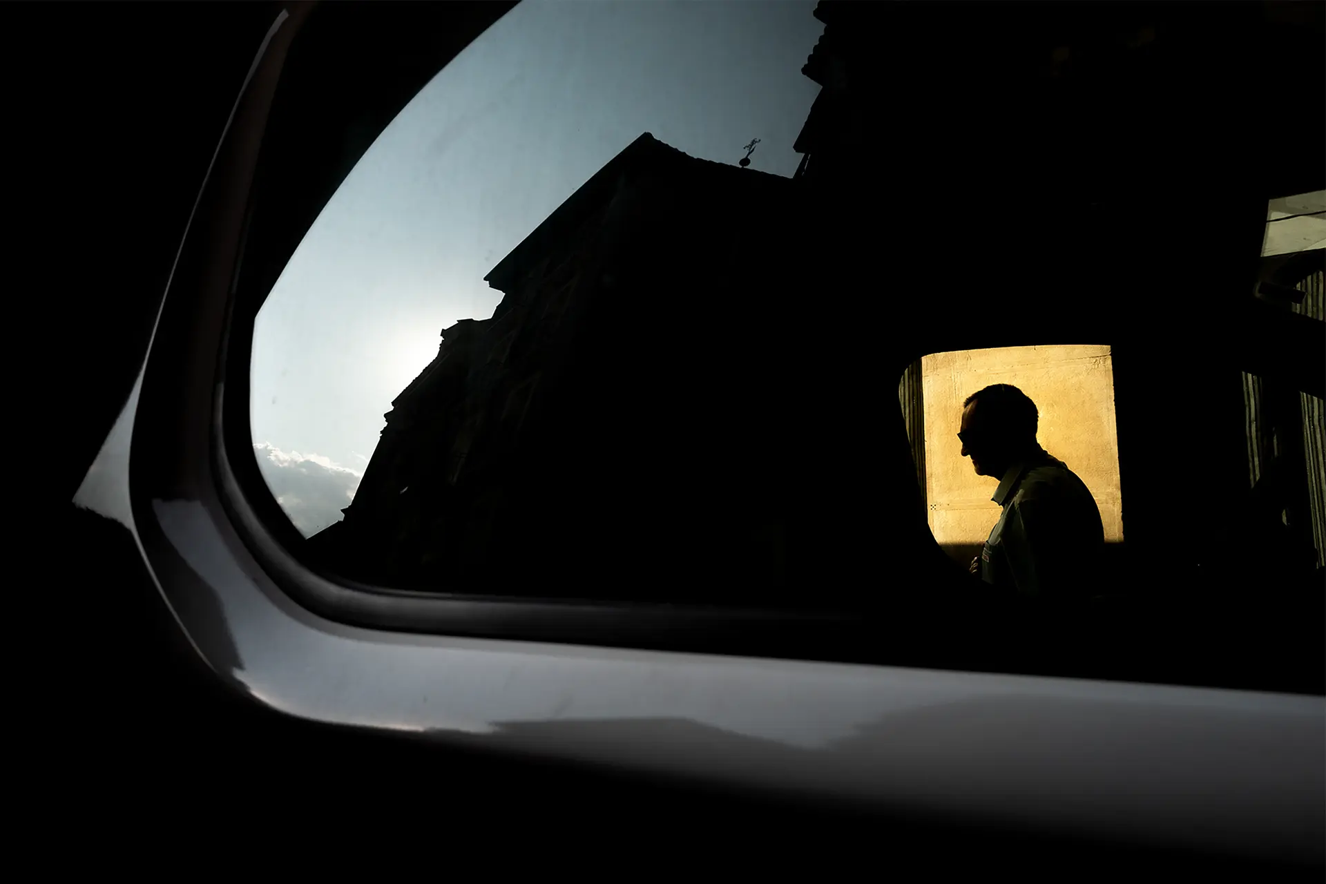 Reflection of a man in a car mirror