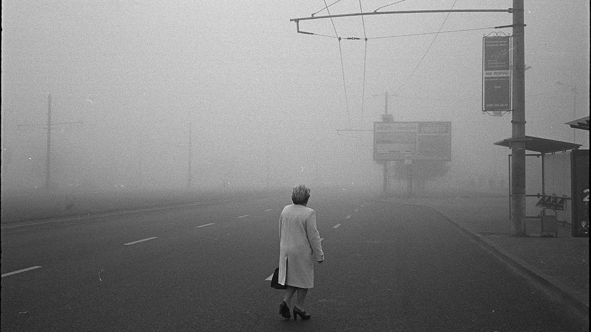 Black and White photograph of a person in a foggy street