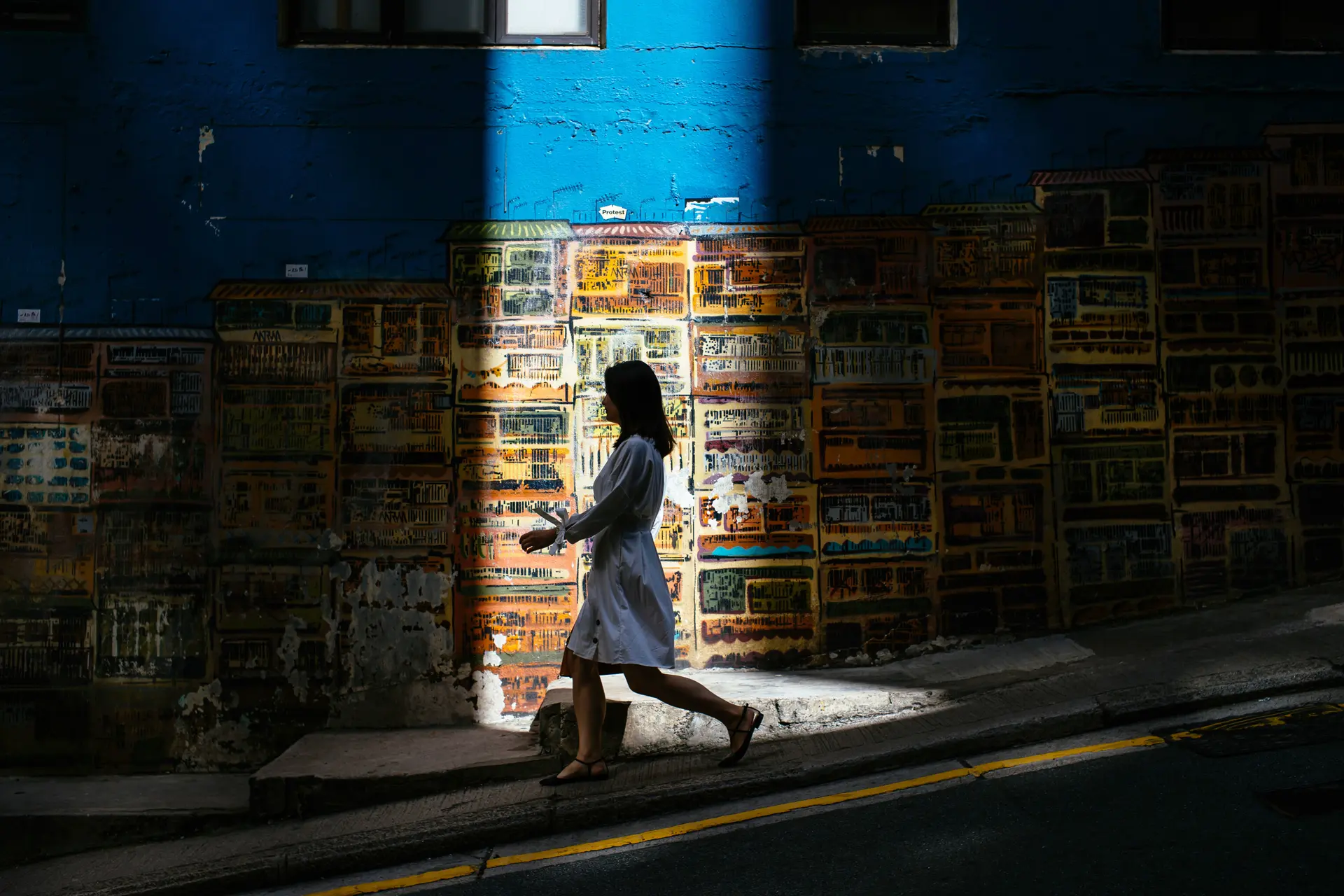 Woman walking down a road with sun shining on her