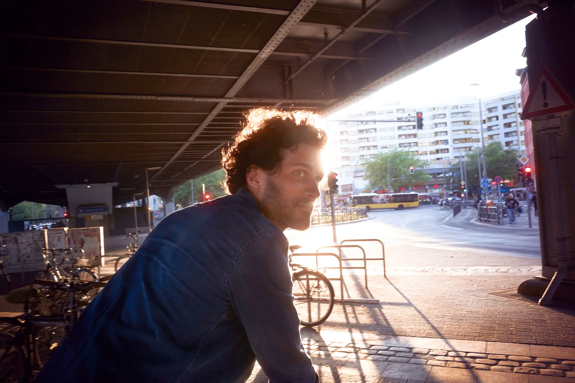 A man stands on a bicycle parking space and looks into the city.