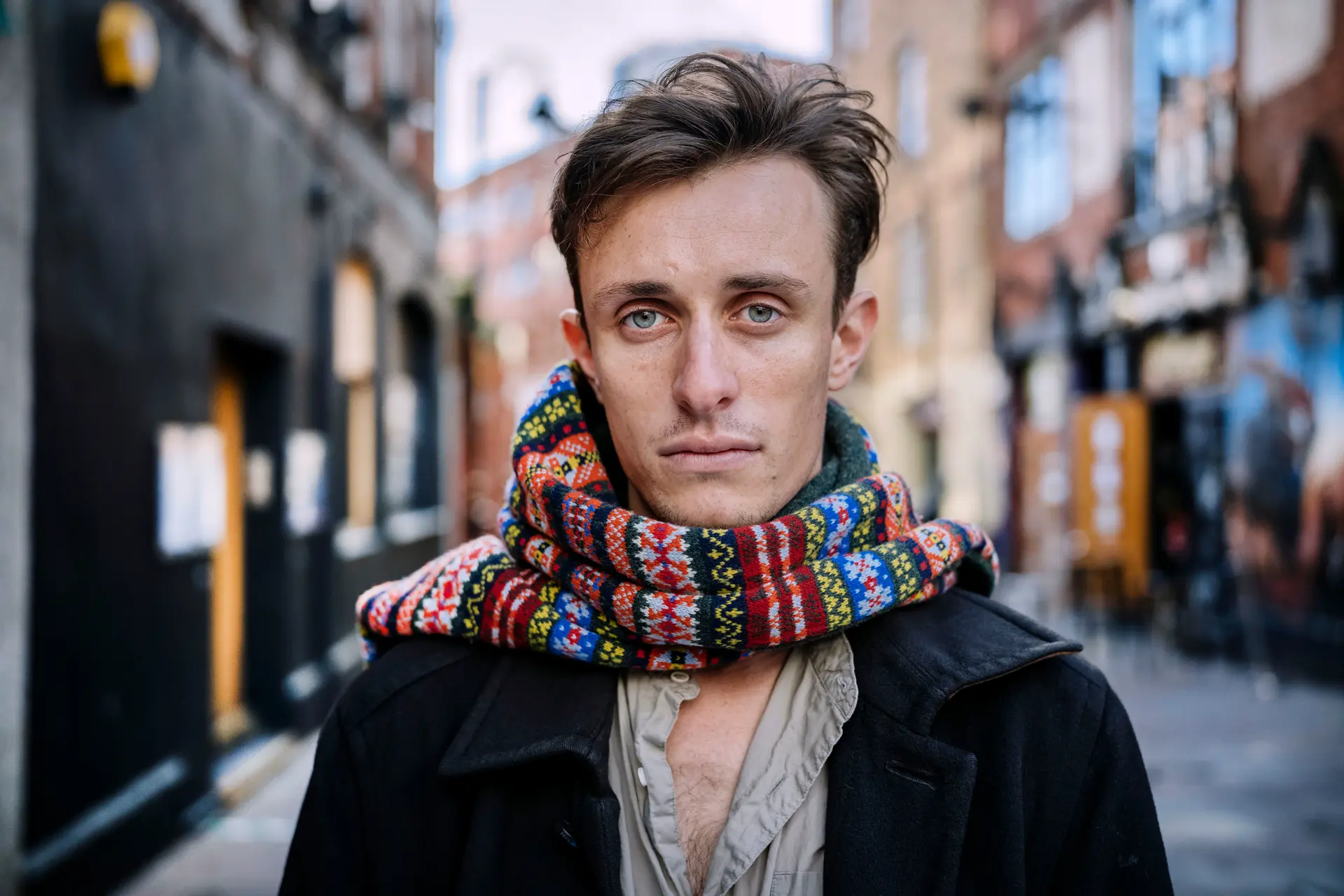 A man with a scarf in a city
