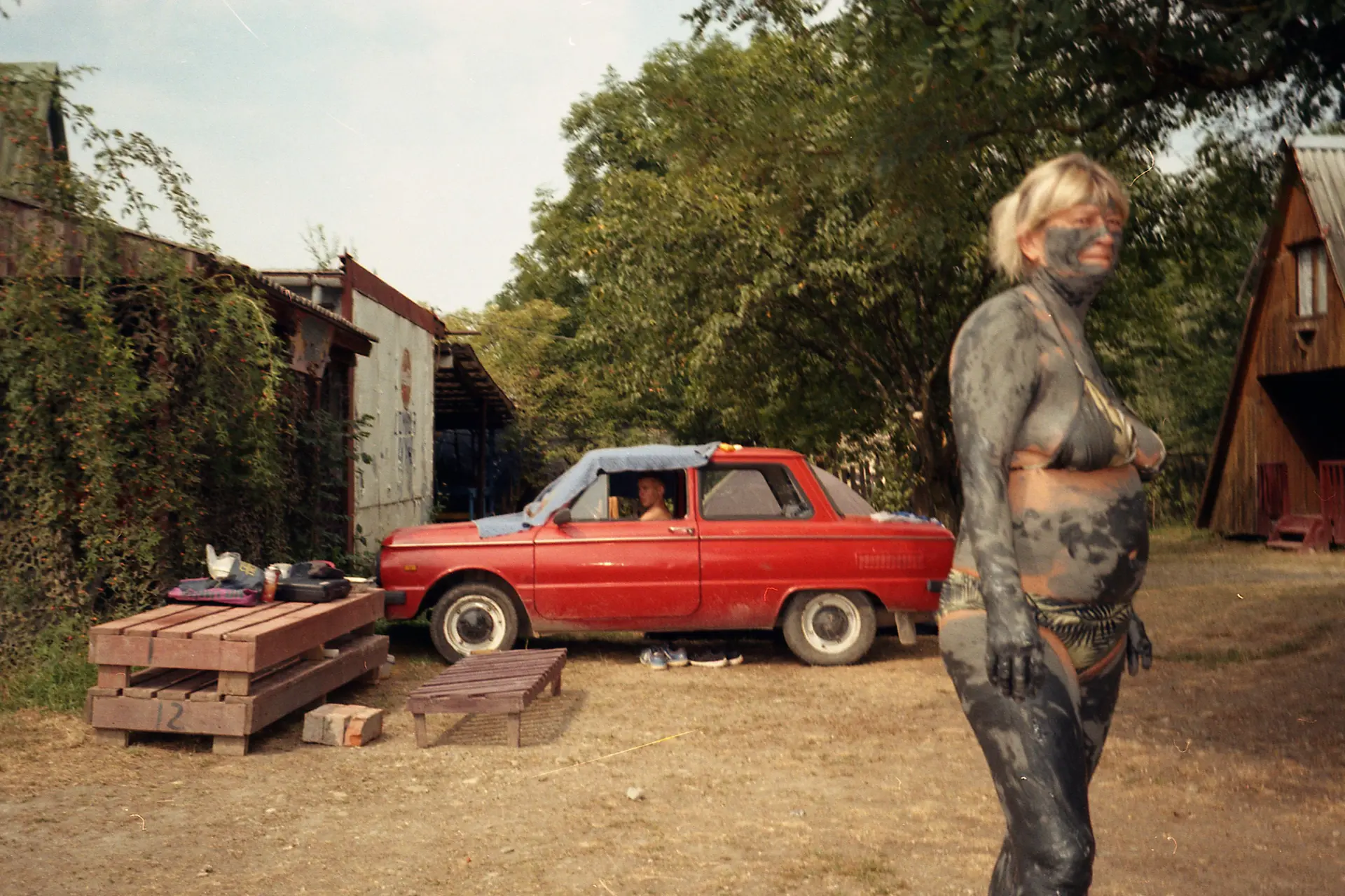 A woman in front of a red car