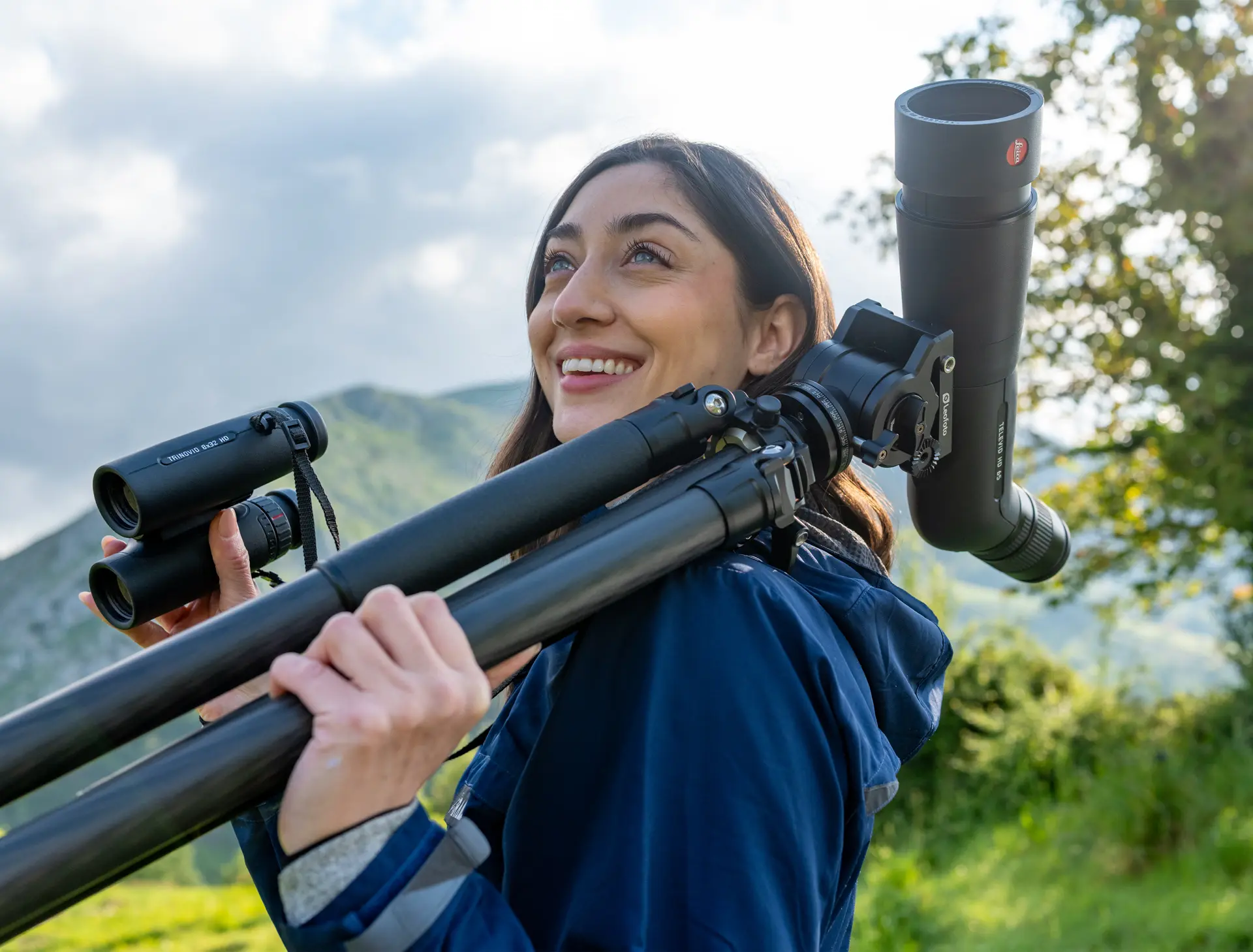 Woman birdwatching in the mountains with Leica APO-Televid spotting scope and Leica Ultravid binoculars, enjoying nature observation with premium Leica optics.