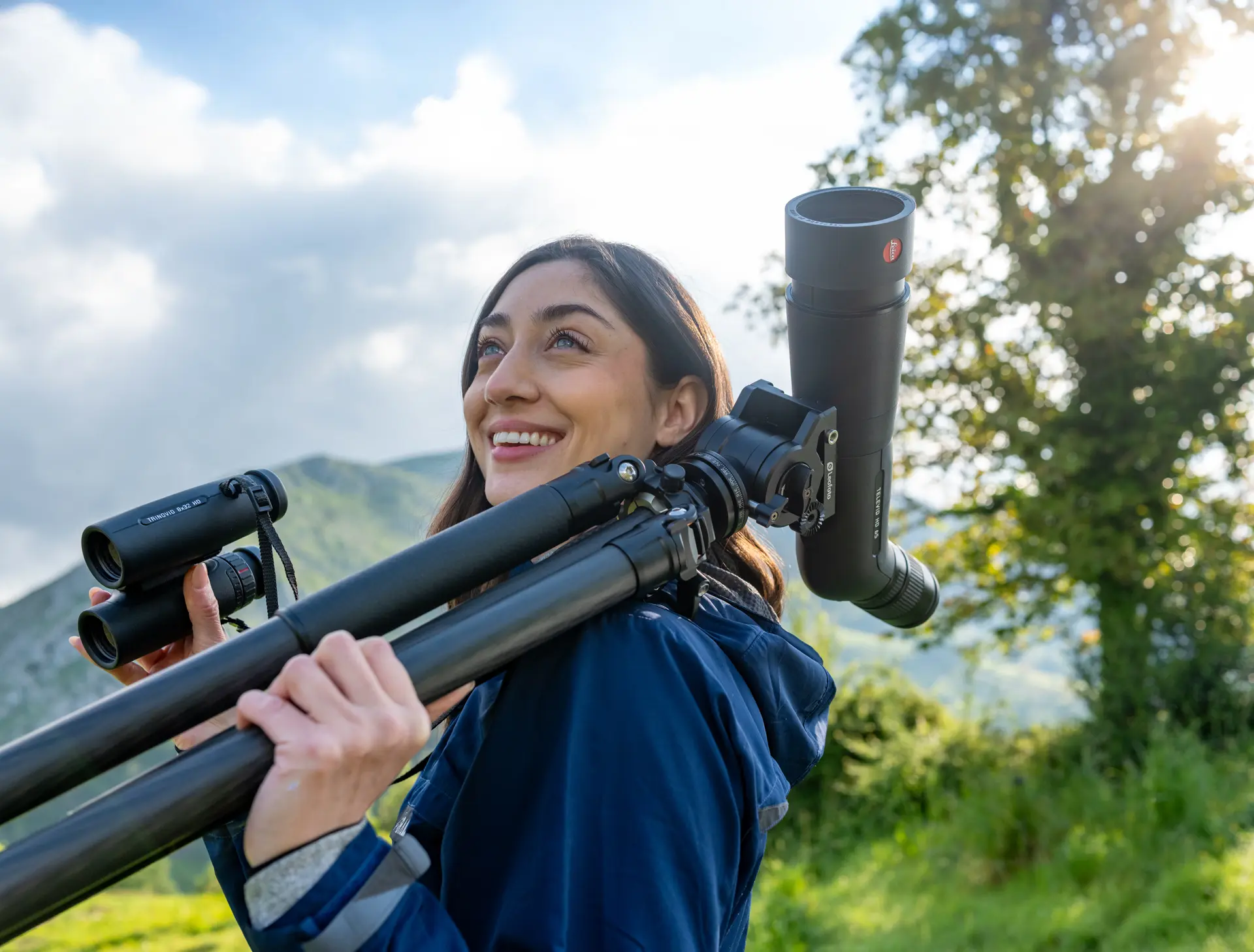 Woman birdwatching in the mountains with Leica Televid spotting scope and Leica Trinovid binoculars, enjoying nature observation with premium Leica optics.