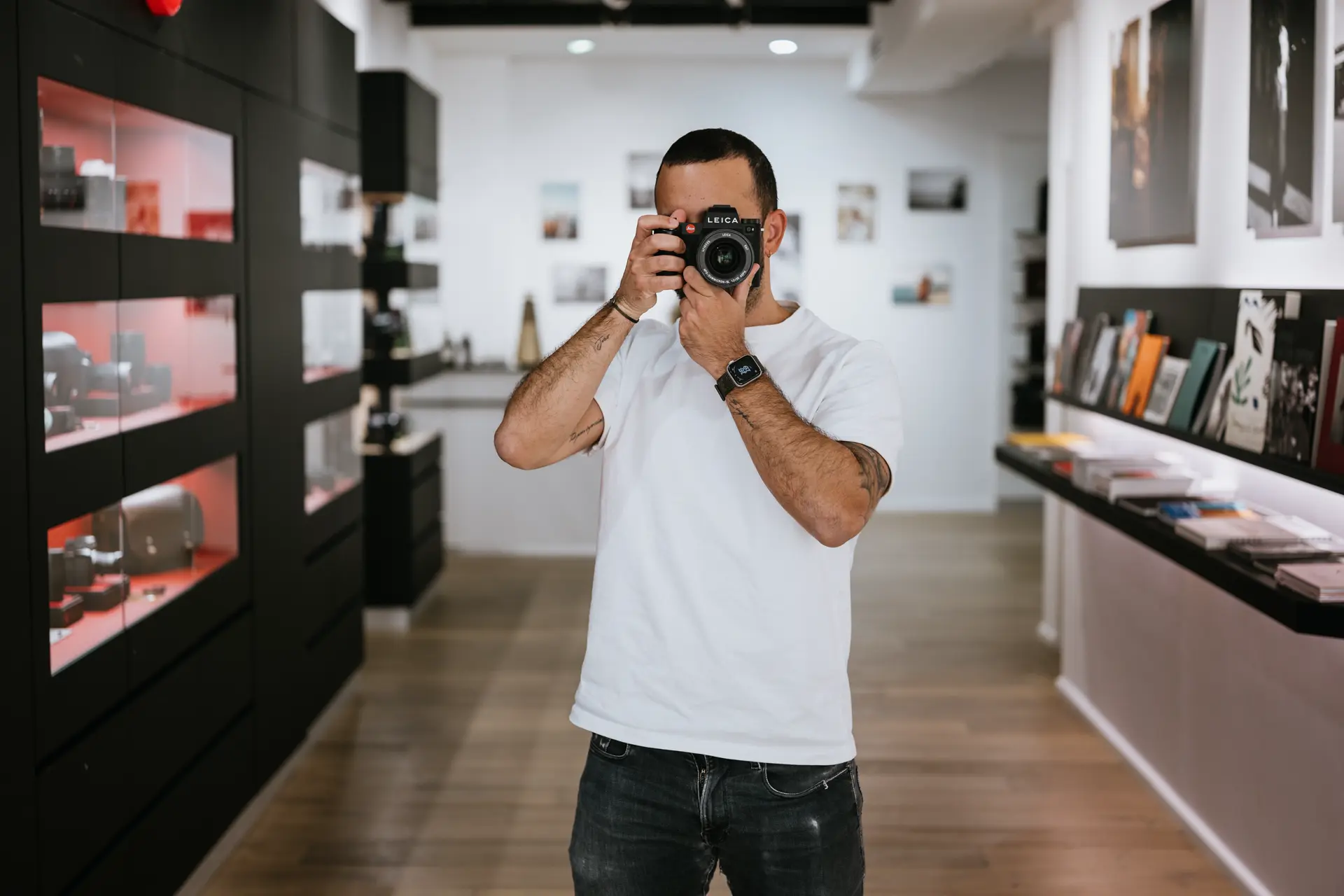 Sales assistant with a leica camera infront of his face in the Leica Store Marseille