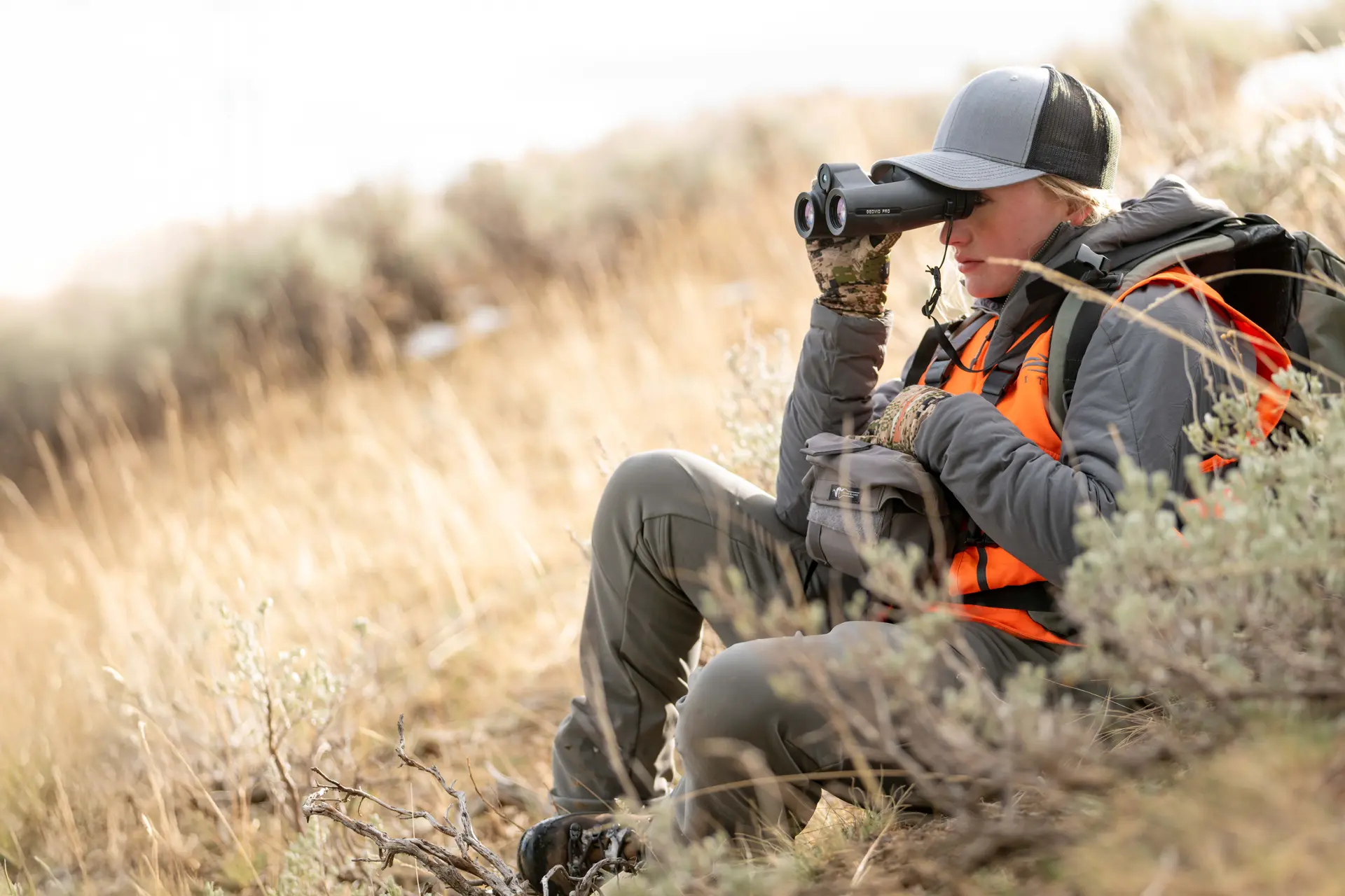 Huntress is looking through her Leica Geovid Pro 10x42