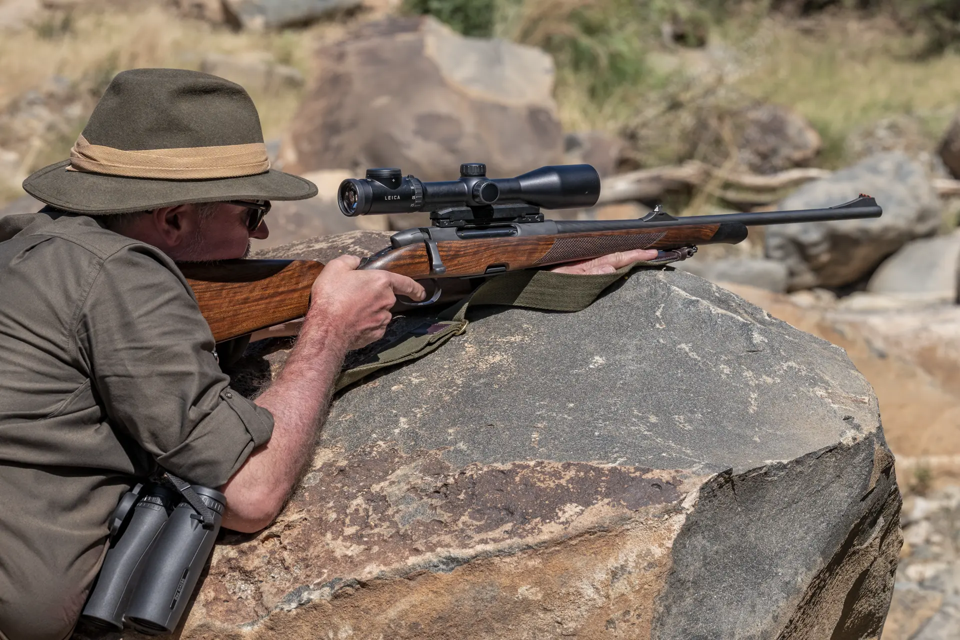 Hunter is lying on a rock and aiming