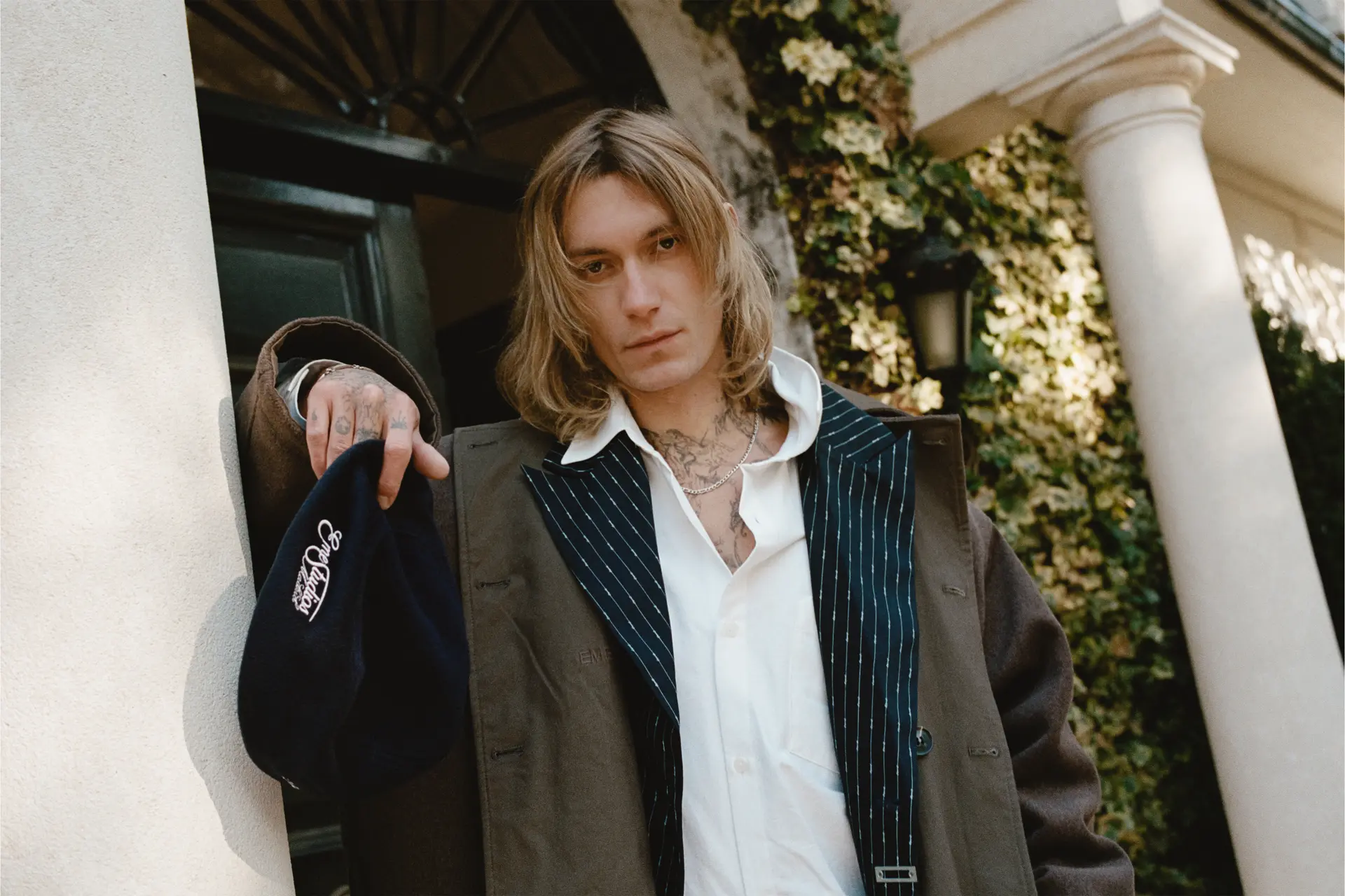 Chico apoyado en una columna en la puerta de una casa