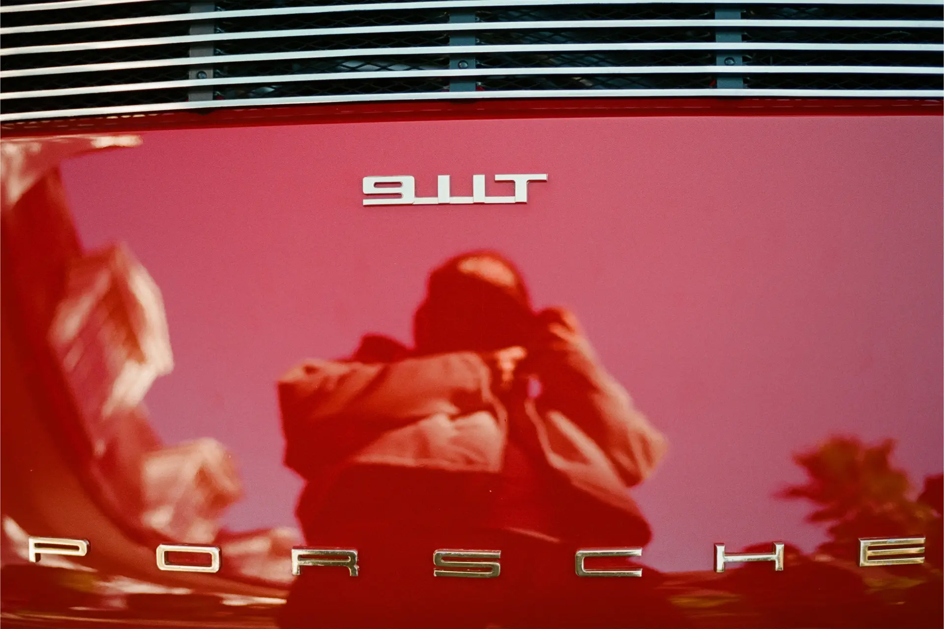 Reflejo de Gabriel Morón en un coche Porsche rojo