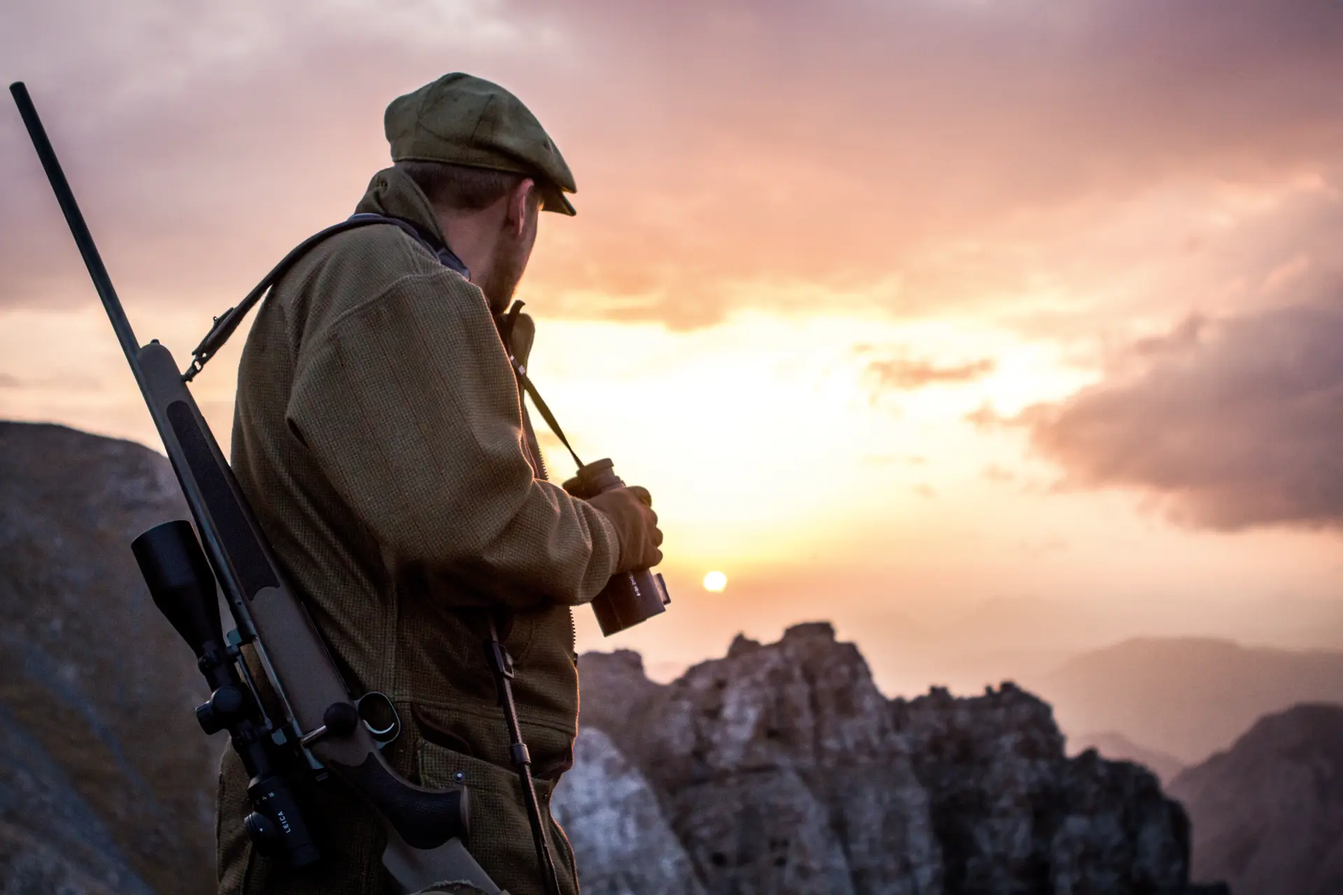 Hunter in the mountains looking into the sunset