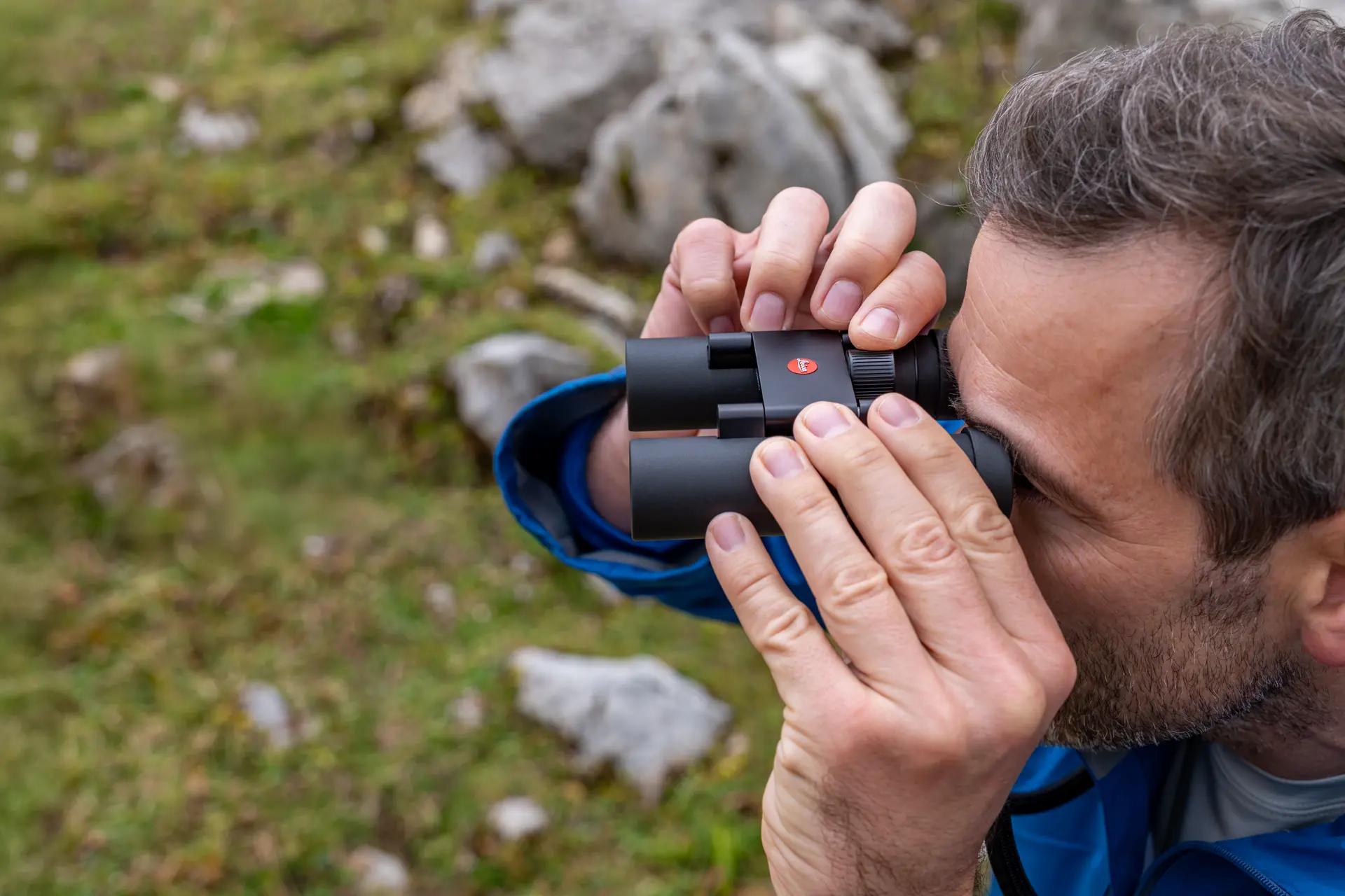 Hiker is looking through his Leica Noctivid Compact
