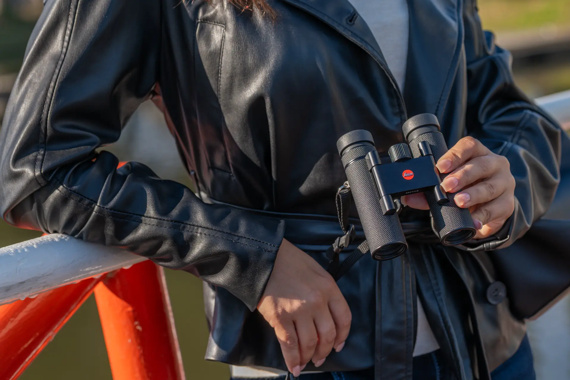 Woman holding her Leica Noctivid Compact
