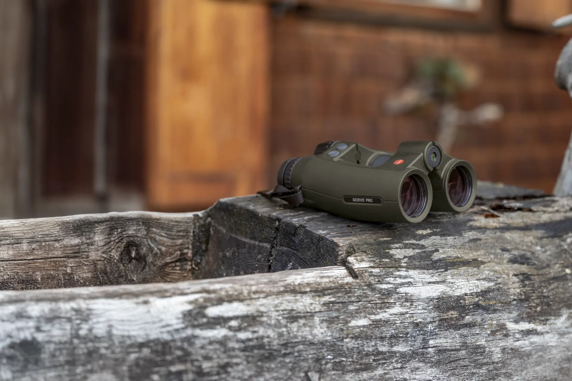 Leica Geovid Pro in olive green is lying on a wooden floor