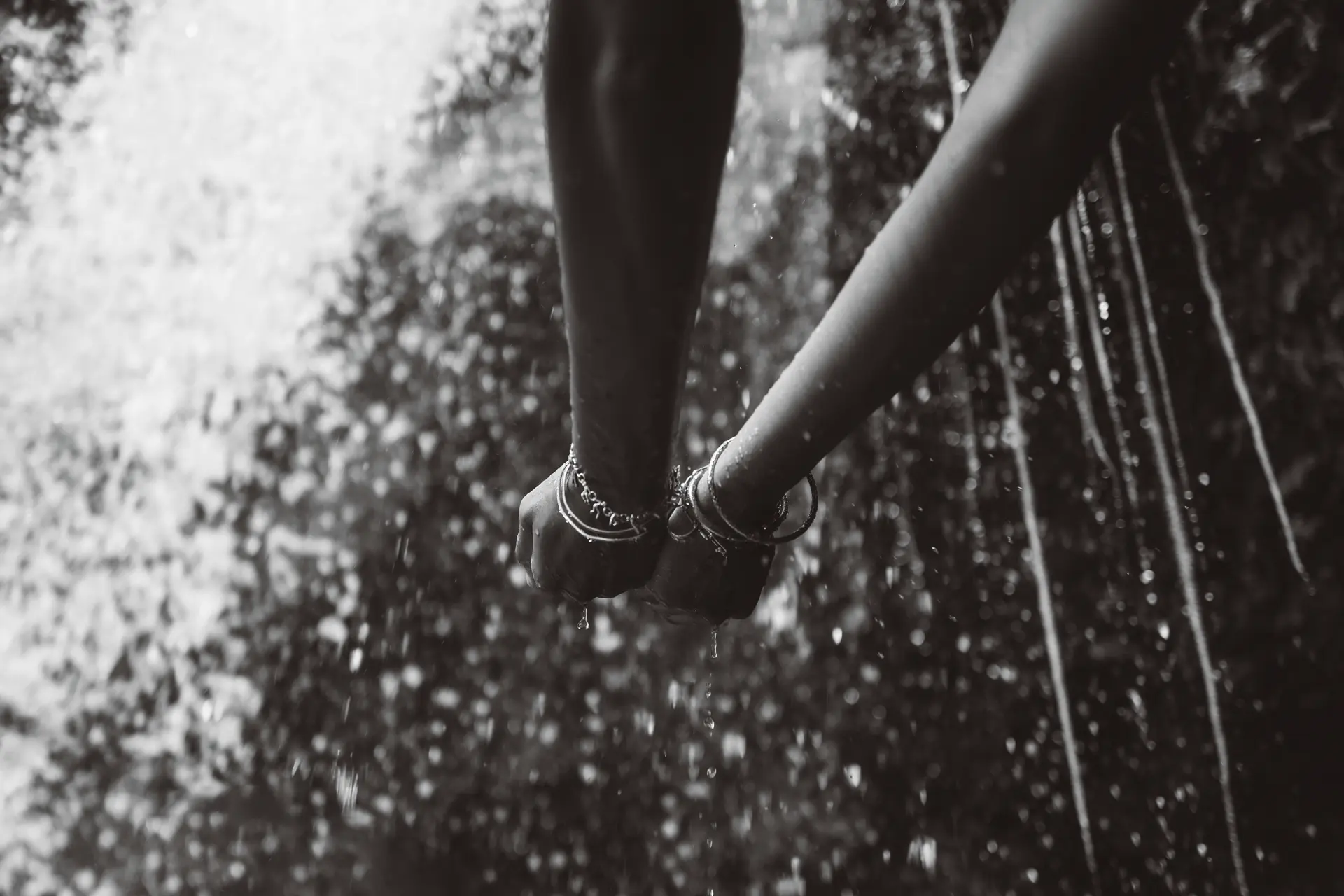Pair of hand gathering water from a fountain 