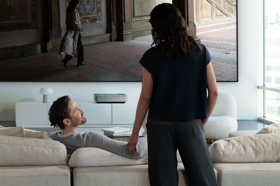 A man and a woman in front of a Leica Cine 1 projection.