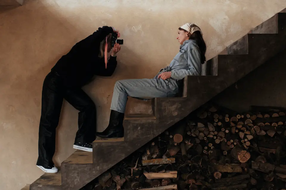 A woman sits on a staircase and is photographed