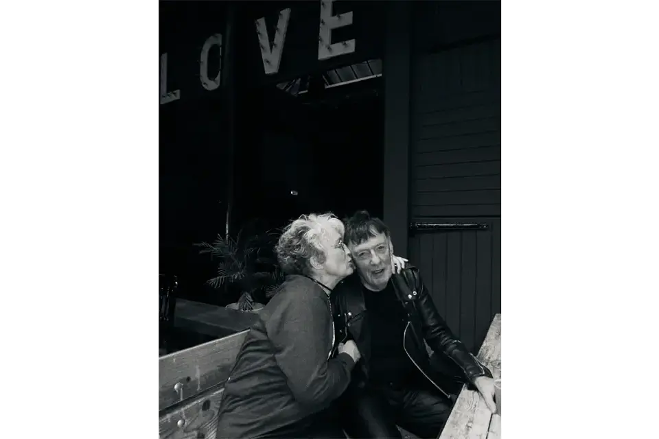 Black and white image of a couple kissing. 