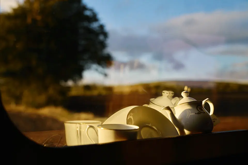 A tea set with the UK country side in the background