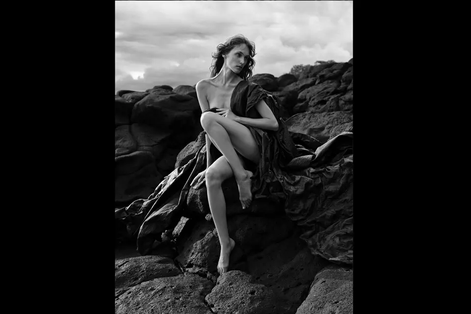 Woman on a rock dressed only with a scarf