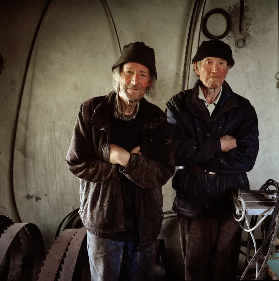 Photograph of two men in a workshop.