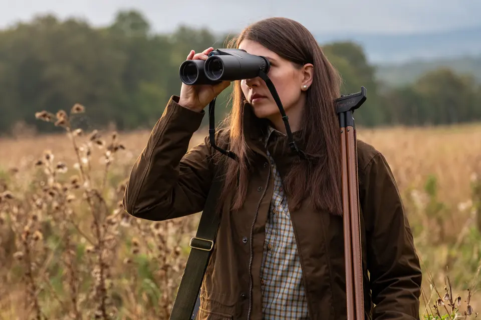 Huntress-observes-a-light-through-Leica-Geovid-R-SE-hunting-binoculars