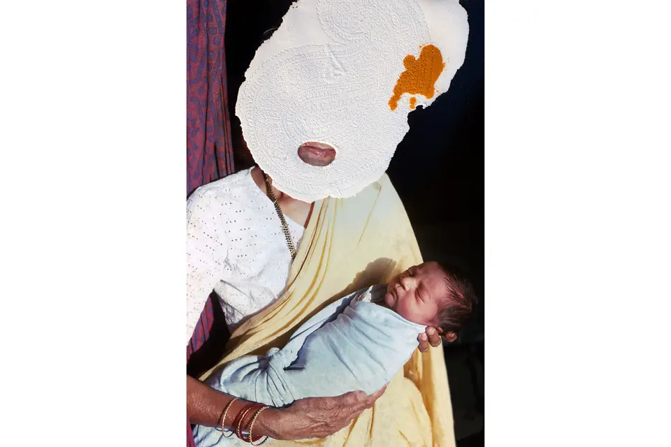 Woman with mask in front of face holding baby in arms