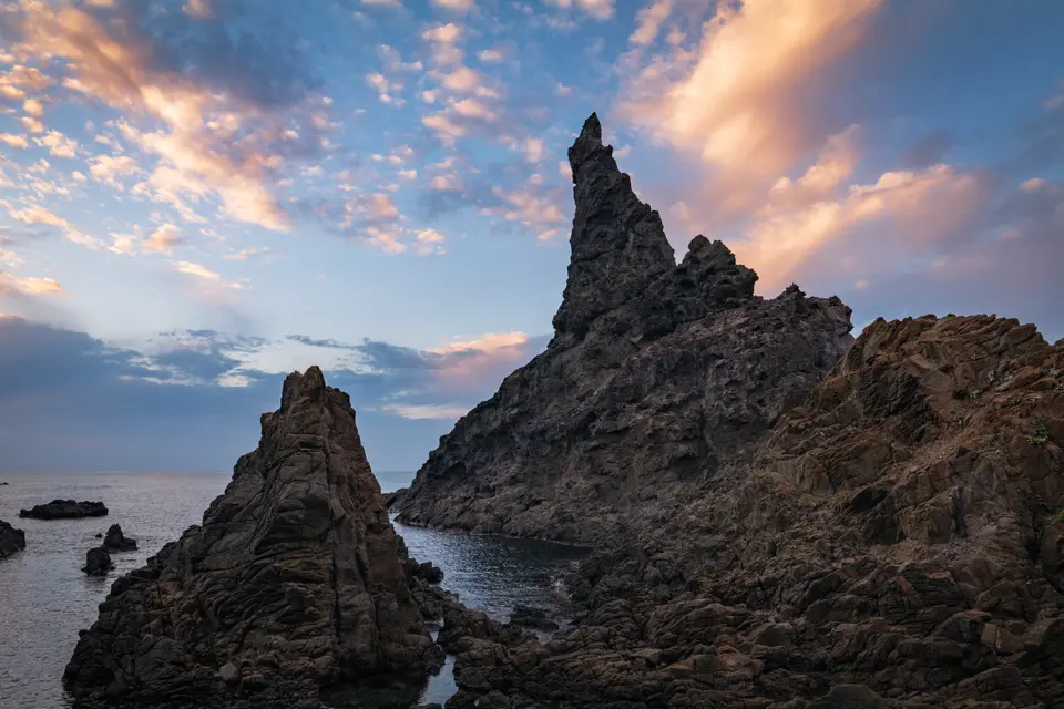 Majestic island: Nishinoshima, sky painted in sunset hues, tranquil sea, gently embracing the fading light.