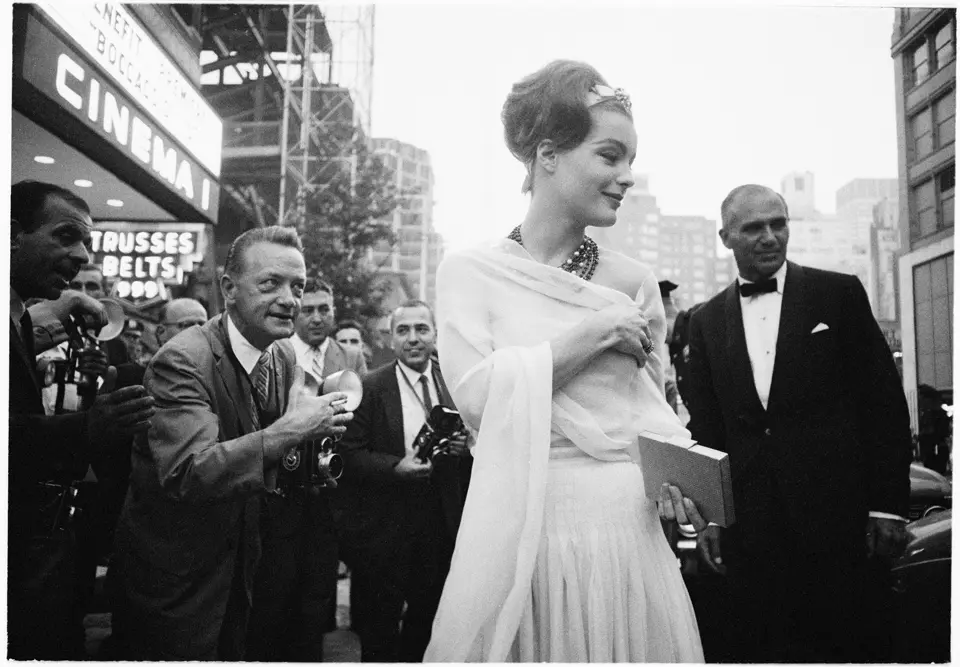 Black and white photograph of Romy Schneider surrounded by paparazzi.