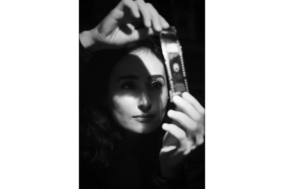 Black and white portrait of a woman holding a film into the light