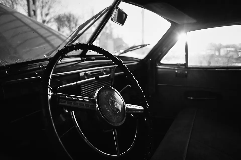 A photo of a steering wheel in an old car.