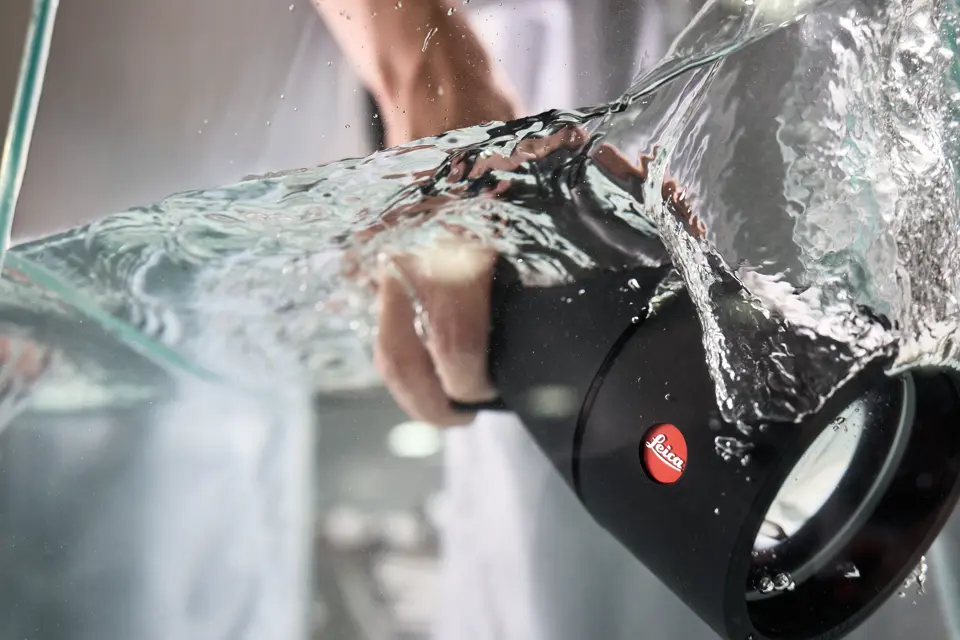 Leica employee puts a Leica spotting scope into the water tank
