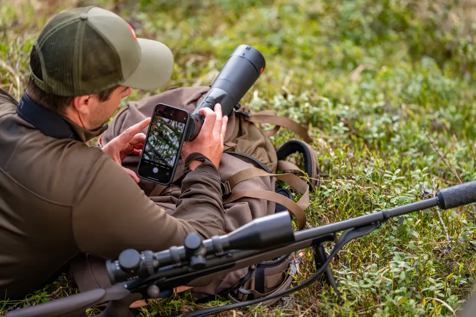 Man is digiscoping with his Televid spotting scope and his smartphone