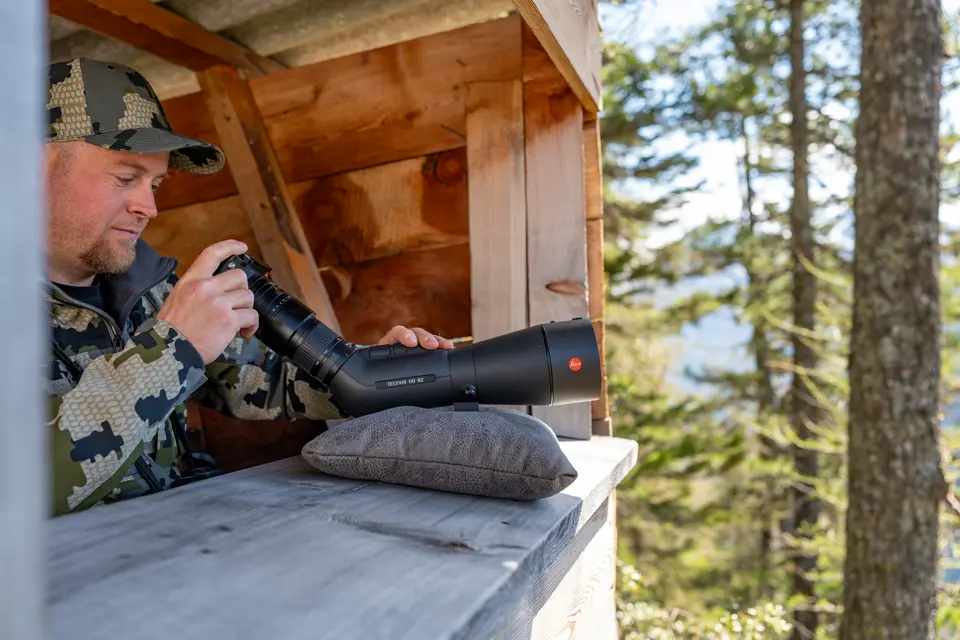 Man is digiscoping with his Televid spotting scope and Leica Q camera
