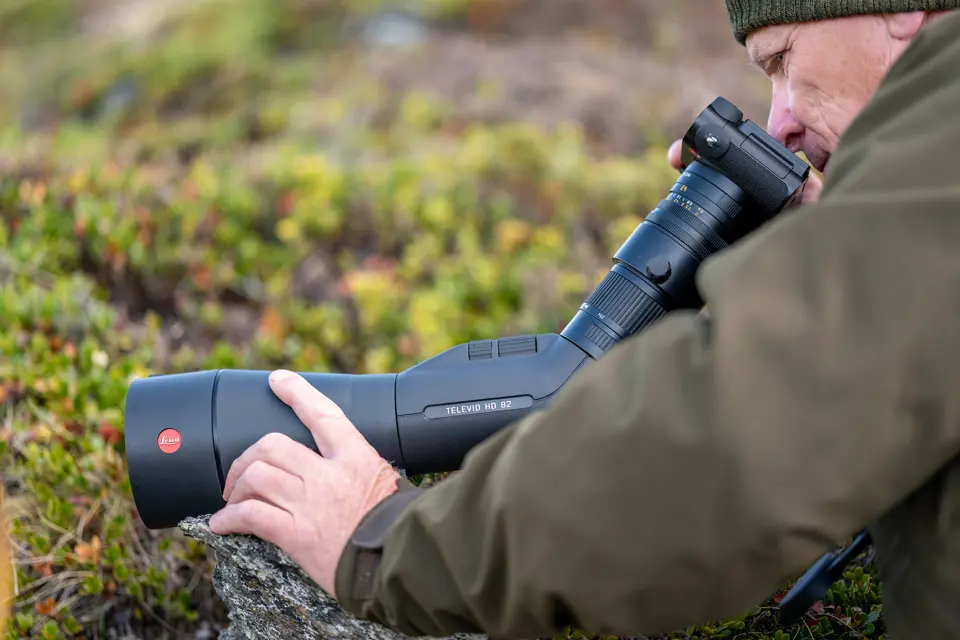 Man is digiscoping with his Televid spotting scope and a Leica Q camera