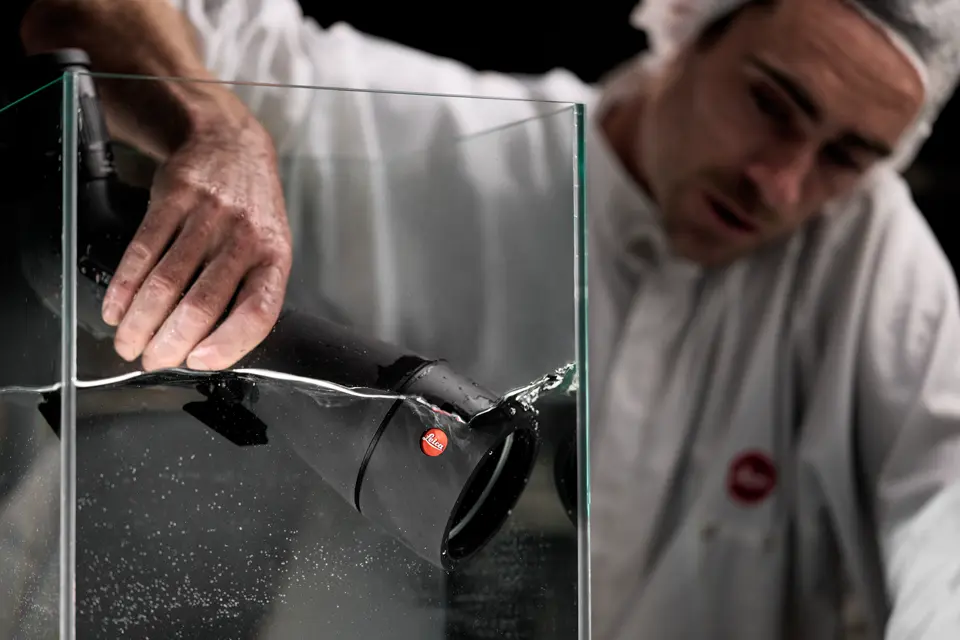 A Leica employee puts a Leica spotting scope in the water tank