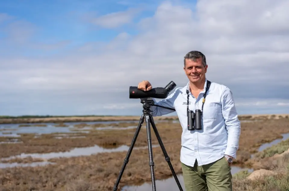 Image of Juan Martin leaning on a Leica Televid wih a Leica binocular hanging on his neck