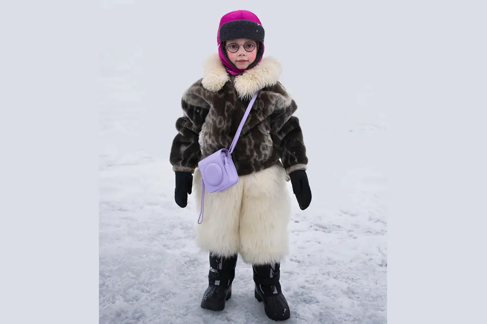 Child in icy landscape with thick fur clothing