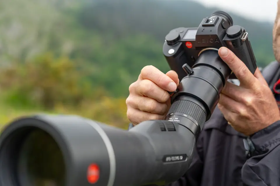 Man is digiscoping with his Leica spotting scope and Leica SL